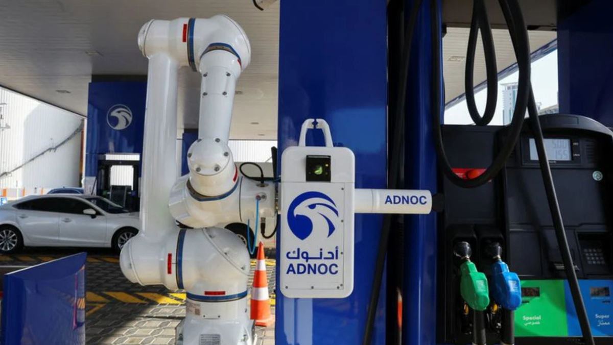 Robotic fueling arm at ADNOC station symbolizing AI adoption in oil operations