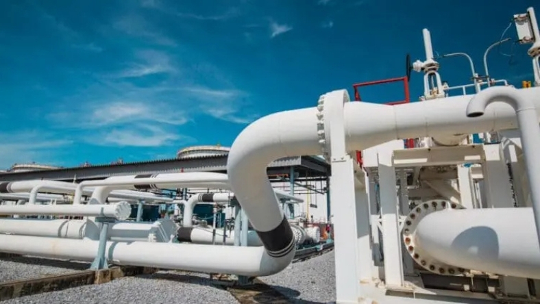 White oil and gas pipeline infrastructure with valves at an industrial energy facility